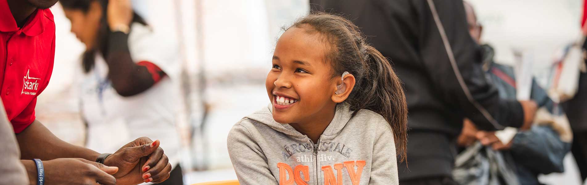 young girl happy speaking to Starkey staff